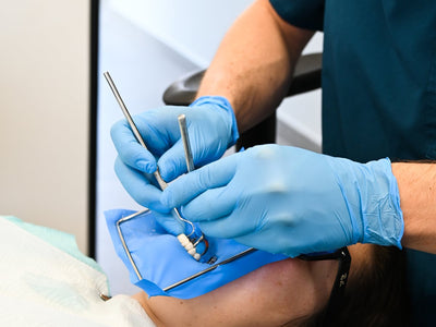Guantes de nitrilo azules en uso en atención dental