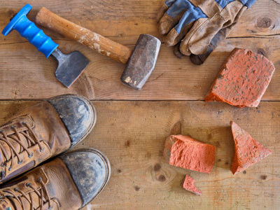 Botas de trabajo gastadas junto a herramientas de construcción