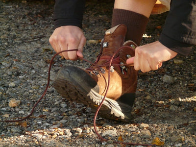Persona amarrando una bota con suela de caucho con tacos